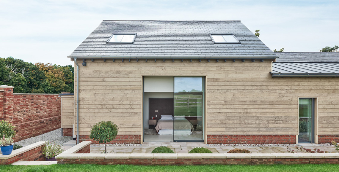 Exterior view of Ellingham Barns - a three-barn conversion project in Dorset, by INKSPACE Architects and Interiors